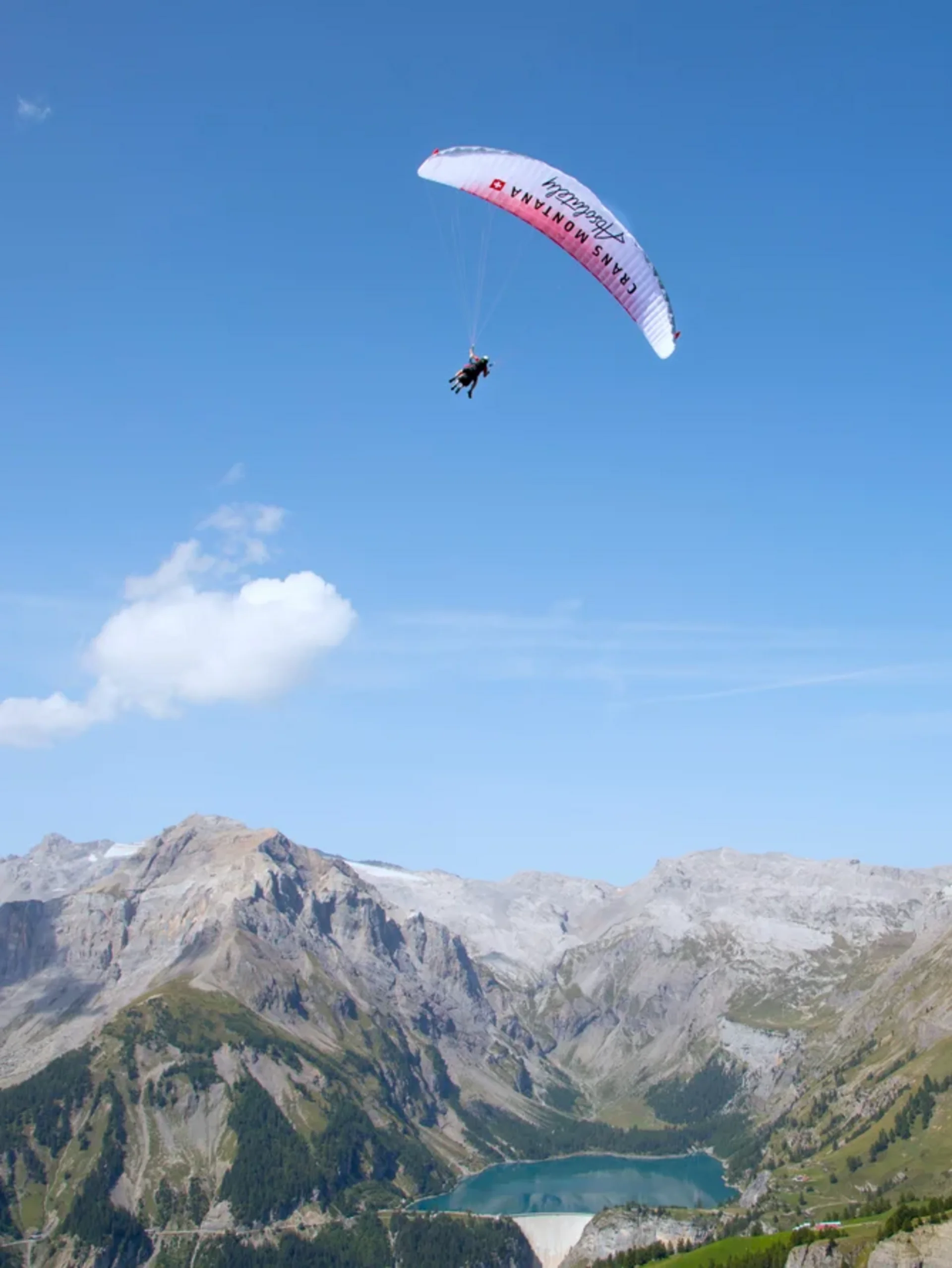 Gleitschirmflug über bewaldeten Hügeln