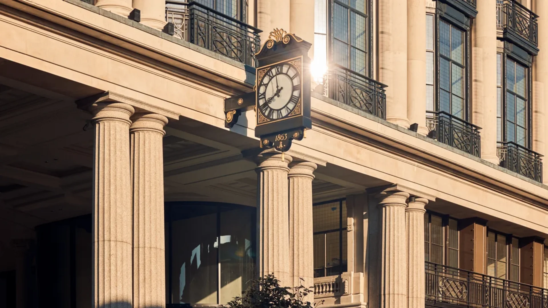 Historische goldene Uhr an klassizistischer Fassade